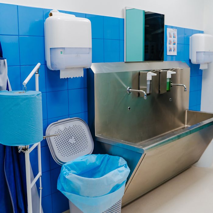 Hand wash room in the hospital. Sterile steel washbasin in modern surgery room